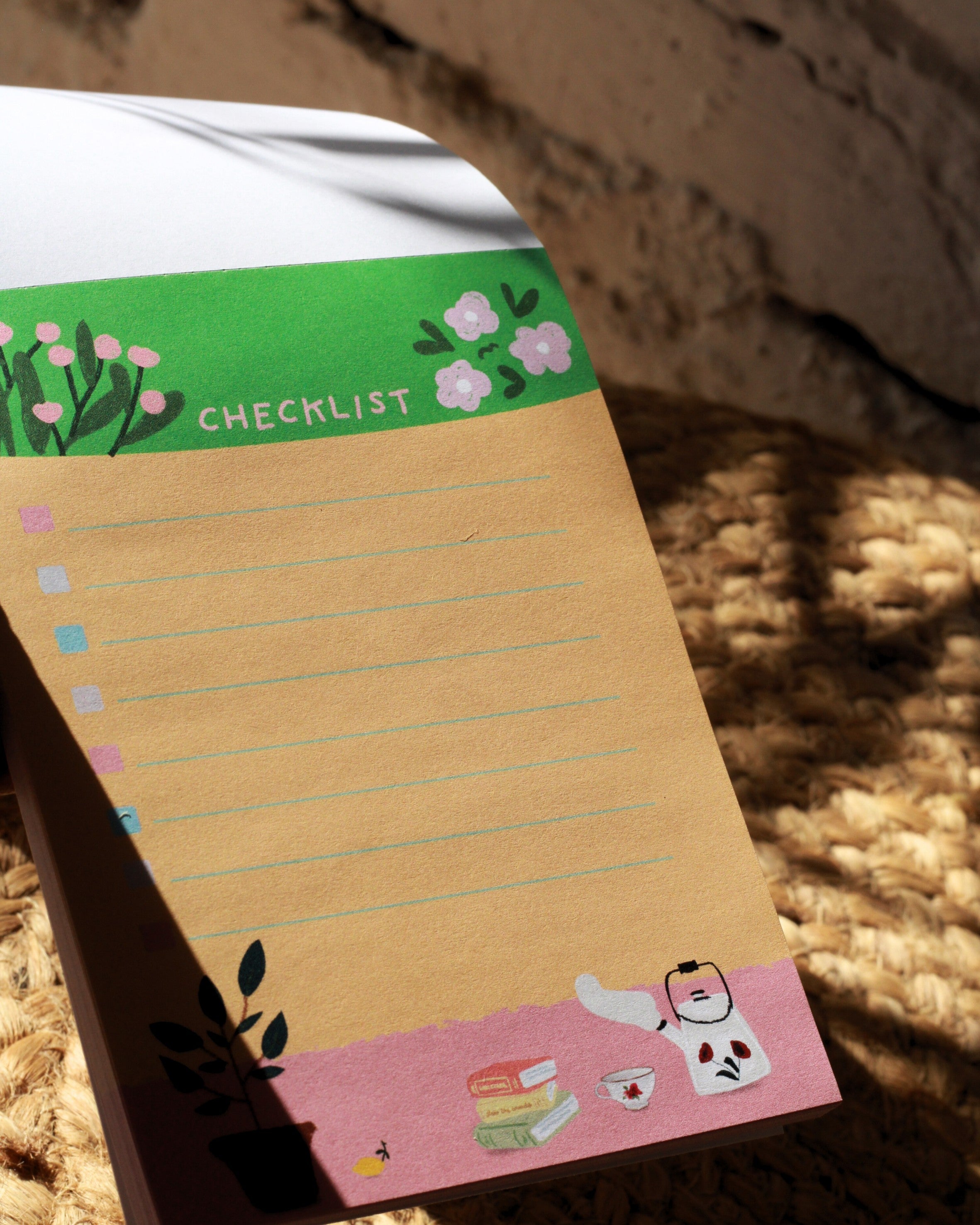 Checklist notepad with decorative elements on a textured surface